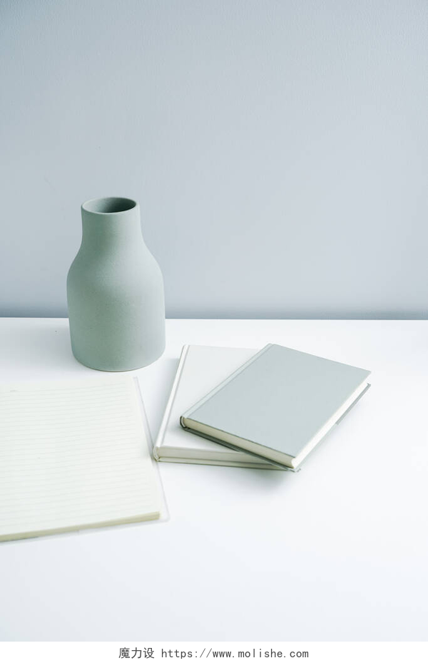 桌上的笔记本和花瓶简约的书本笔记本和平平的花瓶放在桌上.非白色空间的高级家具 